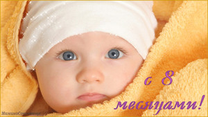 Голубоглазый малыш в желтом полотенце в день 8 месяцев жизни
