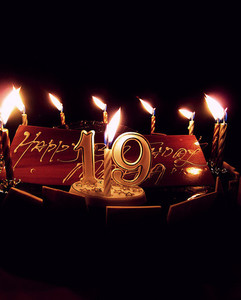 Большой торт с горящими свечками в темноте в день рождения 19 лет