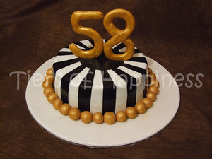 Оригинальный полосатый тортик с золотыми шарикам и цифрой 58